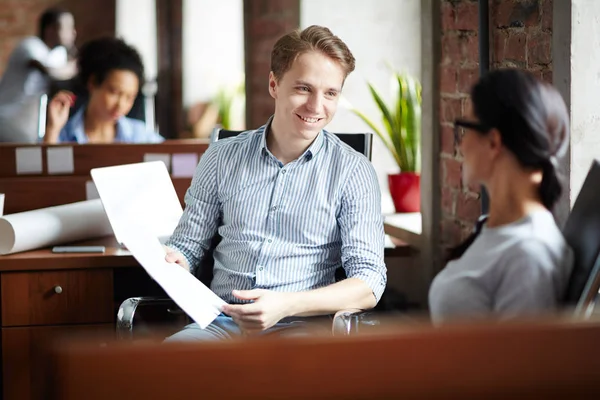 Joven Hombre Negocios Sonriente Discutiendo Documento Junto Con Colega Durante — Foto de Stock