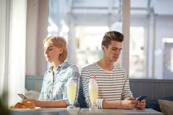 Junges Paar Freizeitkleidung Rücken Rücken Café Und Nachrichten Smartphones — Stockfoto