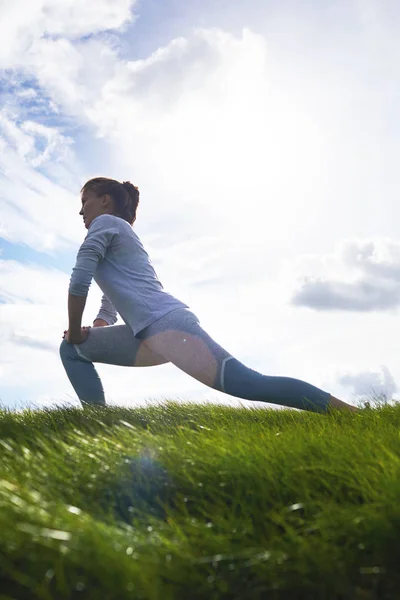 Mulher Ativa Esticando Pernas Enquanto Faz Exercício Gramado Verde Pela — Fotografia de Stock