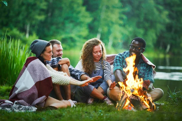 Several Young Backpackers Sitting Campfire Waterside Warming Hands — Stock Photo, Image