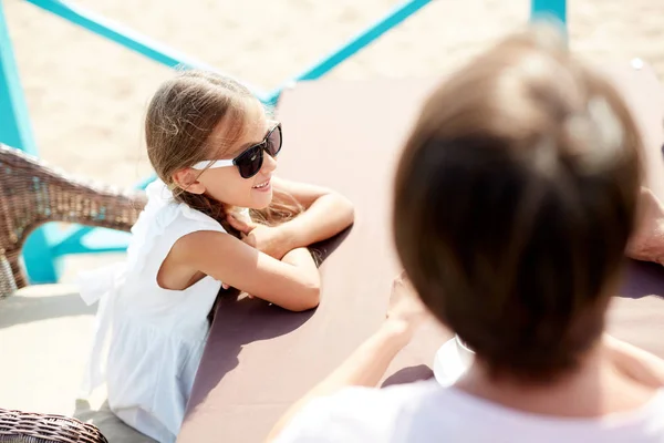 夏休みを楽しむ両親と屋外カフェに座ってサングラスをかけた笑顔の小さな女の子の高角の肖像画 コピースペース — ストック写真