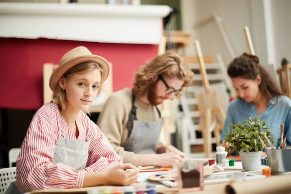 Joven Hembra Mirándote Sentada Junto Mesa Ambiente Trabajo Pintando —  Fotos de Stock