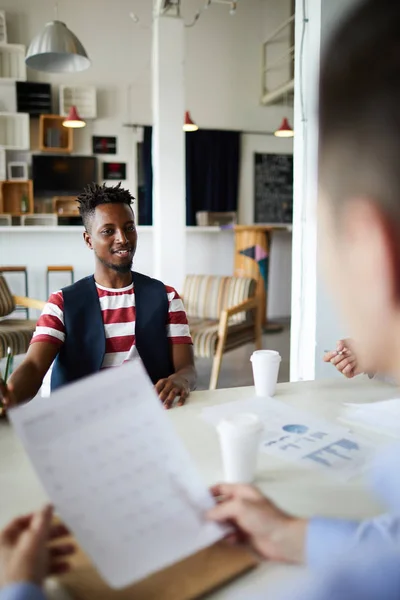 Lächelnder Junger Afrikanischer Geschäftsmann Sitzt Tisch Und Kommuniziert Mit Seinen — Stockfoto