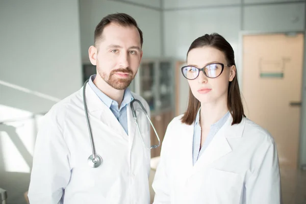 Deux Jeunes Cliniciens Whitecoats Regardant Caméra Dans Les Cliniques Contemporaines — Photo