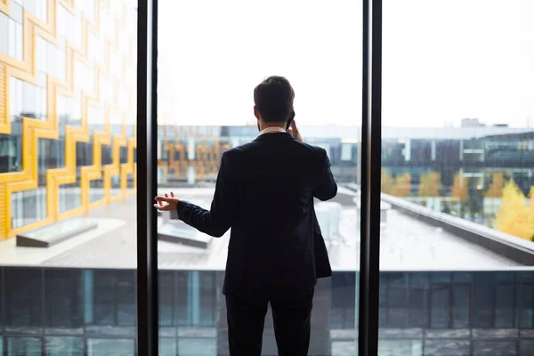 Back View Modern Businessman Suit Standing Window Talking Smartphone — Stock Photo, Image