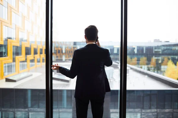 Vue Arrière Homme Affaires Moderne Costume Debout Près Fenêtre Parlant — Photo