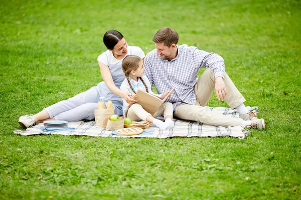 Young Parents Little Daughter Sitting Green Lawn Relaxing Reading Book — 스톡 사진