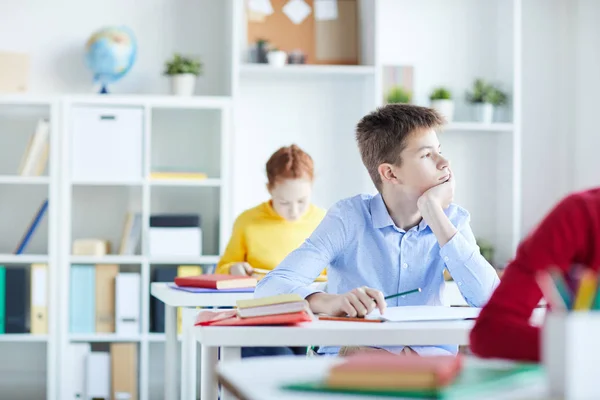 Pensive Eller Uttråkad Skolpojke Sitter Vid Lektionen Och Tittar Genom — Stockfoto