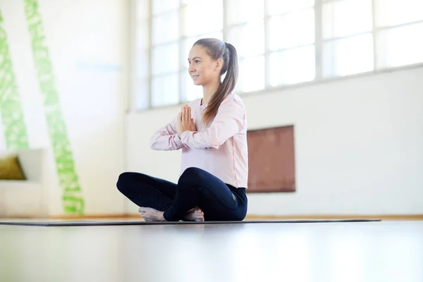 年轻的活跃女运动员坐在瑜伽或瑜伽工作室的地板上独自锻炼 — 图库照片
