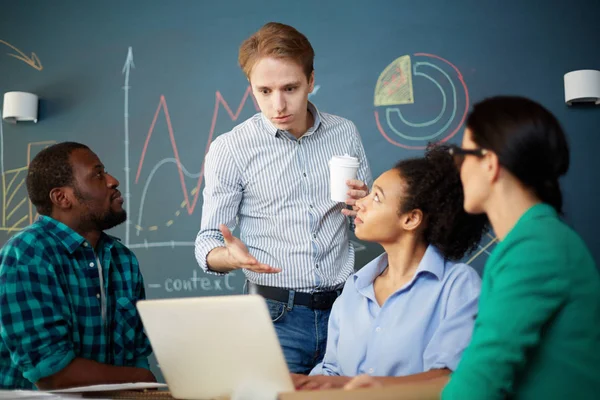 Ung Affärsman Tittar Bärbar Dator Och Diskuterar Presentation Med Sina — Stockfoto