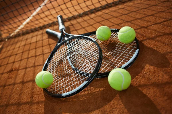 つの新しいテニス ラケットと砂浜のコートで背景にネットでのボール — ストック写真
