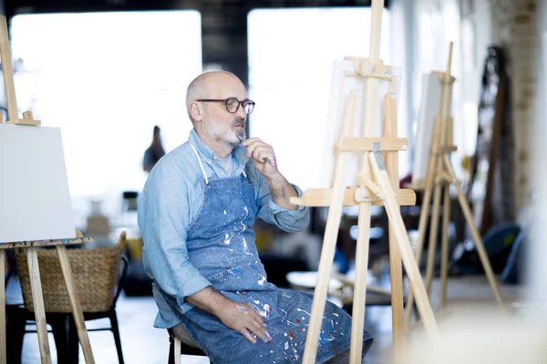 Homem Pensativo Avental Trabalho Olhando Para Pintura Concentrando Escolha Cor — Fotografia de Stock