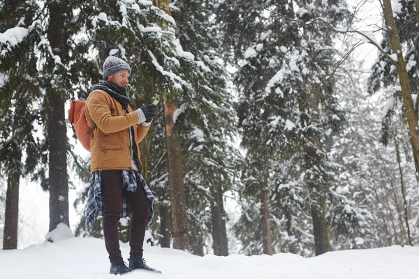 Serious Young Male Hiker Warm Coat Standing Winter Forest Using — Stock Photo, Image