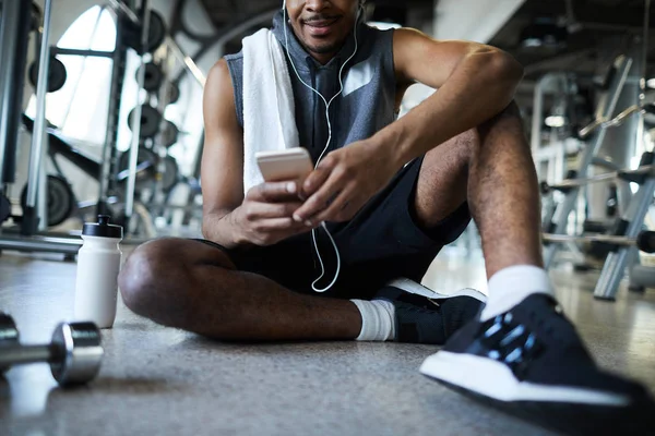 Afrikanisch Amerikanischer Sportler Sitzt Mit Smartphone Auf Dem Boden Entspannt — Stockfoto