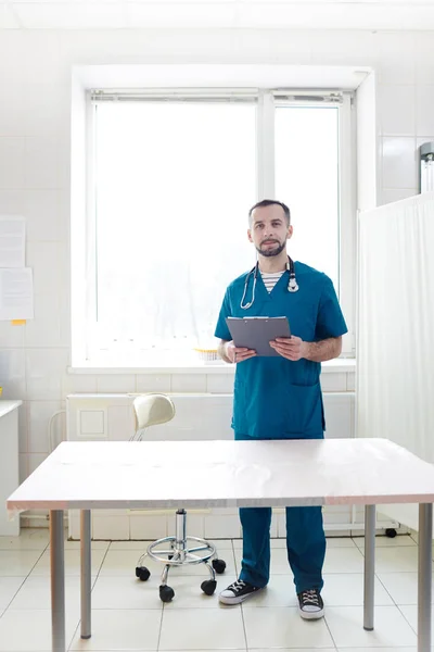 Joven Médico Con Documento Pie Junto Mesa Médica Para Sus —  Fotos de Stock