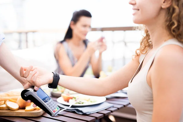 年轻而又聪明的现代女性在支付食物费用的同时 还能在电子支付机上保持手腕畅通 — 图库照片