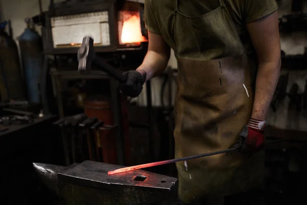 铁匠在统一站在铁锤和锻造热金属工件用锤子 — 图库照片