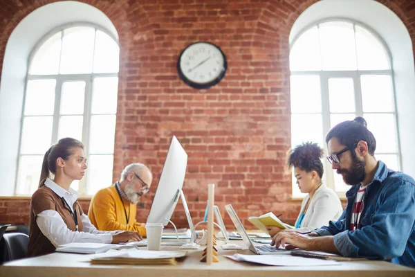 Quattro Direttori Ufficio Seduti Alle Scrivanie Uno Fronte All Altro — Foto Stock