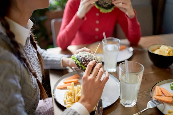 Mladá Dívka Její Přítelkyně Mají Cheeseburgery Smažené Hranolky Oběd Kavárně — Stock fotografie