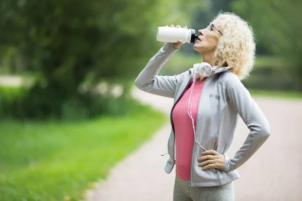 Blonde Mature Woman Drinking Water Plastic Bottle While Standing Road — Stock Photo, Image