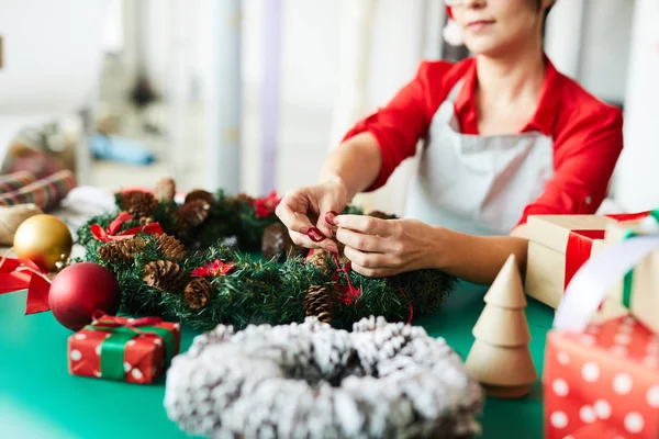 Jonge Ontwerper Bindt Rood Lint Kerstkrans Versierd Met Dennenappels — Stockfoto