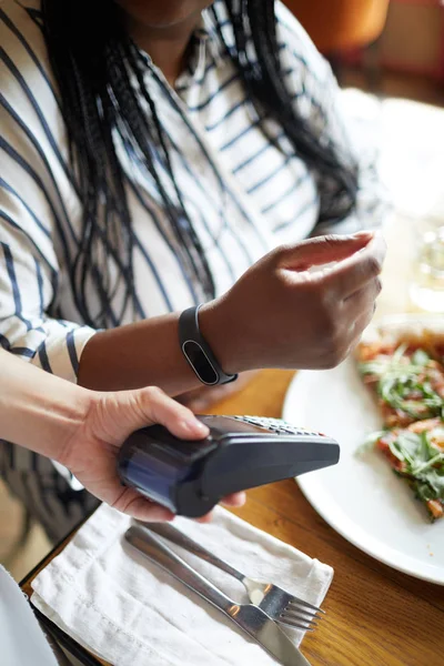 Jeden Klientów Kawiarni Trzymając Rękę Smartwatch Blisko Maszyny Płatniczej Posiadaniu — Zdjęcie stockowe
