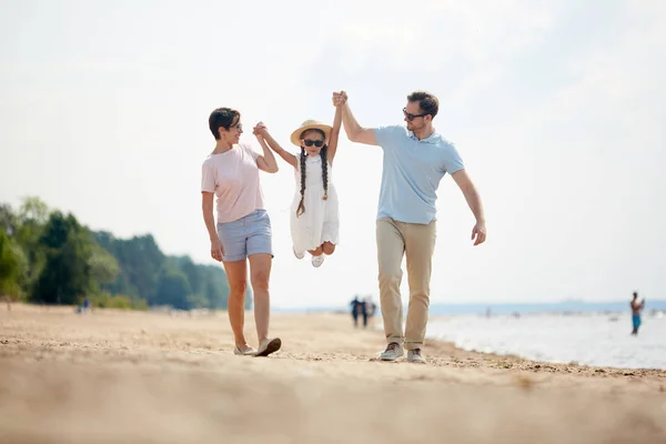 Młody Ojciec Matka Podnoszą Swoją Córeczkę Przez Piaszczystą Plażę Podczas — Zdjęcie stockowe