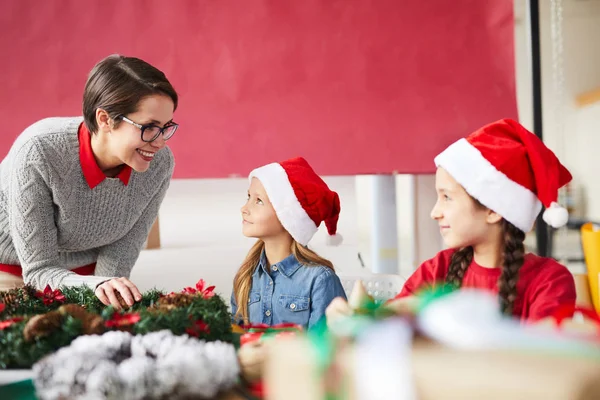 Dwa Małe Santas Patrząc Ich Mama Podczas Świątecznych Przygotowań Domu — Zdjęcie stockowe