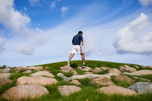 Young Man Sportswear Walking Big Stones Green Field Part His — Stock Photo, Image