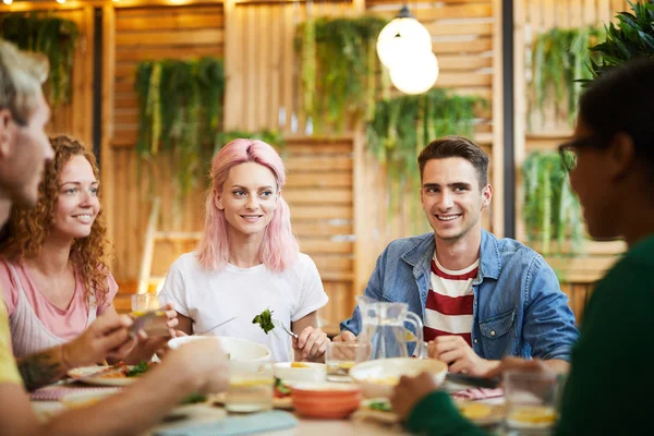 居心地の良いカフェでお祝いの夕食で会話中に友人を見ている4人の仲間 — ストック写真