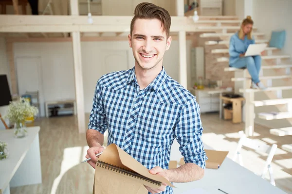 Sorrindo Jovem Homem Casual Com Bloco Notas Fazendo Anotações Trabalho — Fotografia de Stock