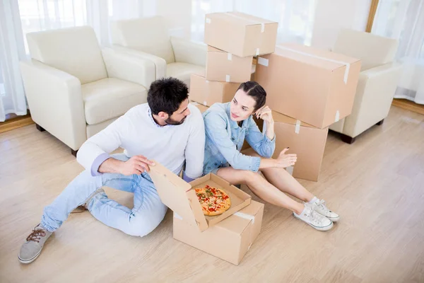 Mladí Manželé Jedí Pizzu Internetu Mluví Novém Domě Podlaze — Stock fotografie