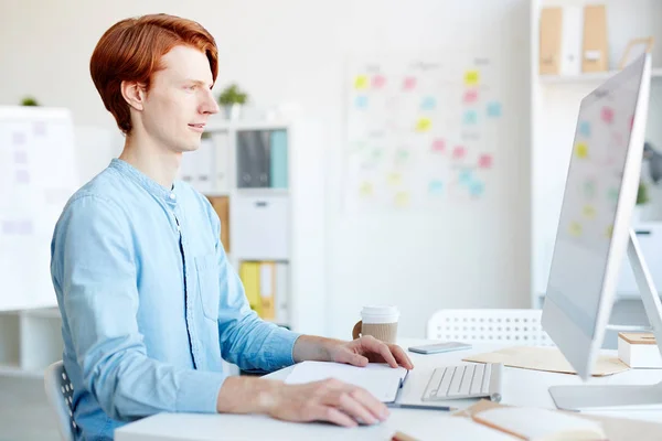 Seriöser Rothaariger Männlicher Grafiker Blauen Hemd Der Büro Arbeitet Betrachtet — Stockfoto