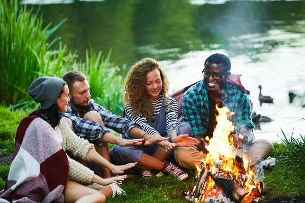 Jonge Kampeerders Praten Aan Het Water Terwijl Bij Het Kampvuur — Stockfoto