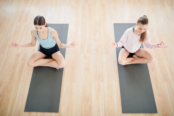 Två Sportiga Cross Legged Tjejer Sitter Pose Lotus Mats Och — Stockfoto