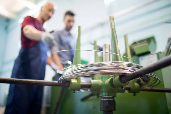 Primer Plano Máquina Con Alambre Dos Mecánicos Trabajando Equipo Discutiendo —  Fotos de Stock