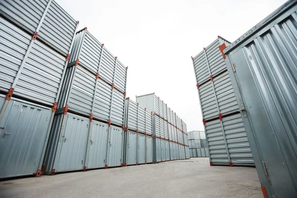 Spacious container storage area with stacking shipping containers under open sky at distribution warehouse