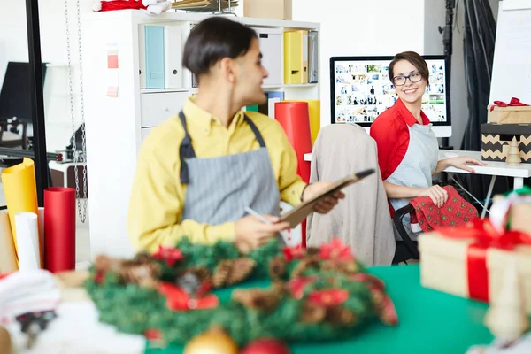 Boldog Fiatal Asztalon Néztem Kollégája Megvitatása Során Xmas Tervek Stúdióban — Stock Fotó