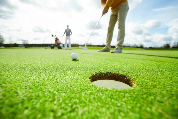 一名高尔夫球手在比赛中将其直接打进草坪上的洞里 图库图片