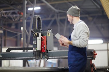 Fabrikanın çağdaş mühendisi iş yerinde teknik makine mekanizmasına bakıyor