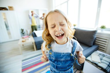 Küçük kız evde ailesinden bir şey talep ederken yüksek sesle bağırıyor