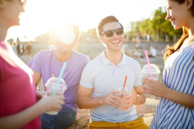 Yaz günü piknik sırasında arkadaşlarıyla konuşmak içki ile Gülen adam