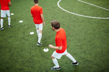 Futbol oyun sırasında yeşil alan satırında bölen çevresinde çalışan genç futbolcuların