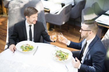 İki genç işadamı restoranda iş öğle yemeği ile meyve suyu bardak ile tost