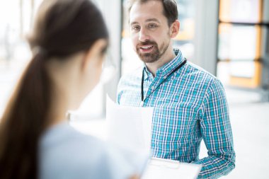 Sözleşmenin şartlarını açıklarken müvekkiline bakan kendinden emin genç bir ajan.
