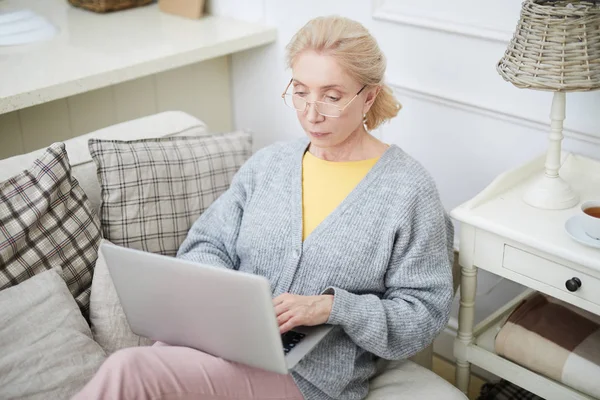 Mujer Edad Grave Sentado Sofá Con Ordenador Portátil Las Rodillas —  Fotos de Stock