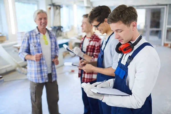 Confident Mature Carpenter Foreman Explaining Tasks Young Workers Overalls Who — Stock Photo, Image