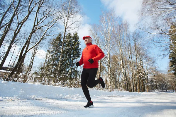 Aktiver Rentner Sportkleidung Läuft Winterliche Straße Hinunter Umgeben Von Bäumen — Stockfoto