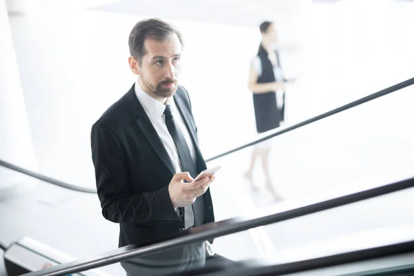 Jonge Zakenman Met Smartphone Sms Terwijl Het Verplaatsen Naar Boven — Stockfoto