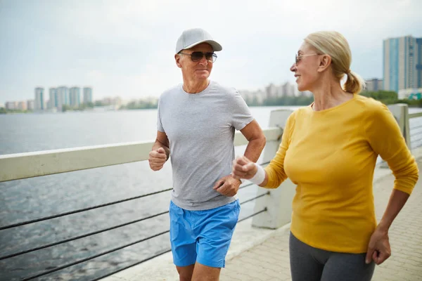 Aktiva Seniorer Solglasögon Jogging Längs Riverside Urban Miljö — Stockfoto